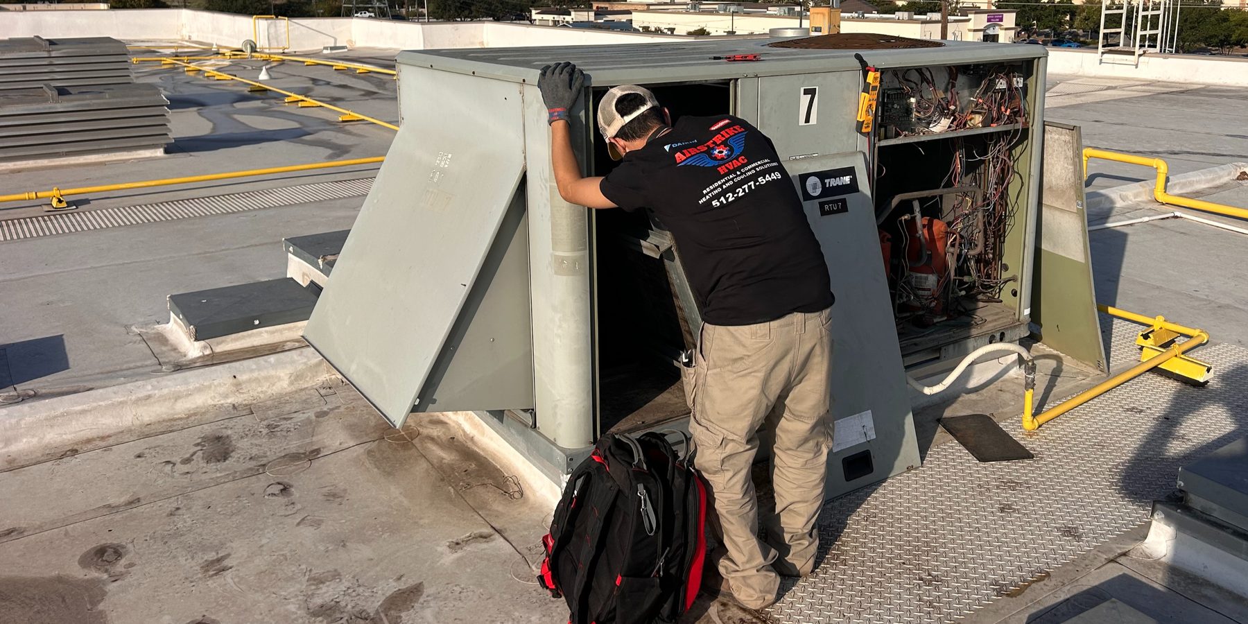 An Airstrike technician completing a rooftop HVAC repair